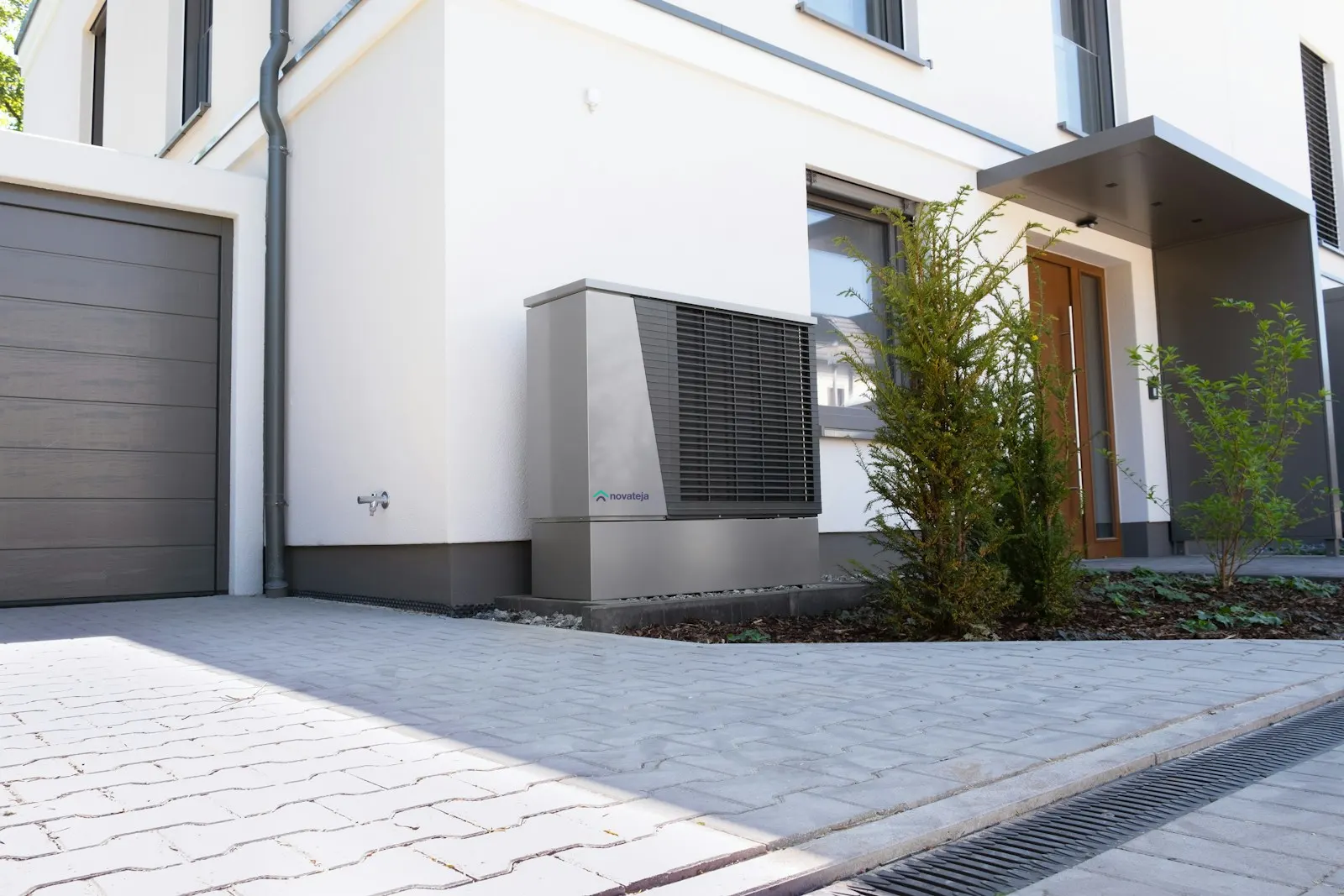 Unitat exterior d'aerotèrmia al costat d'una casa moderna