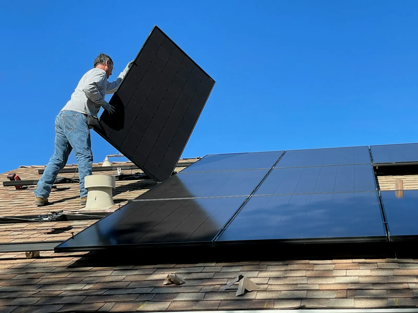 Instal·lador col·locant un panell solar en una teulada